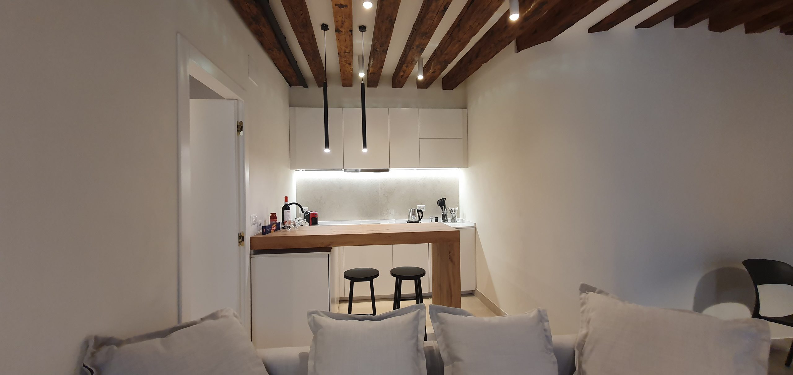 Zona cucina e soggiorno con travi di legno a vista a Venezia