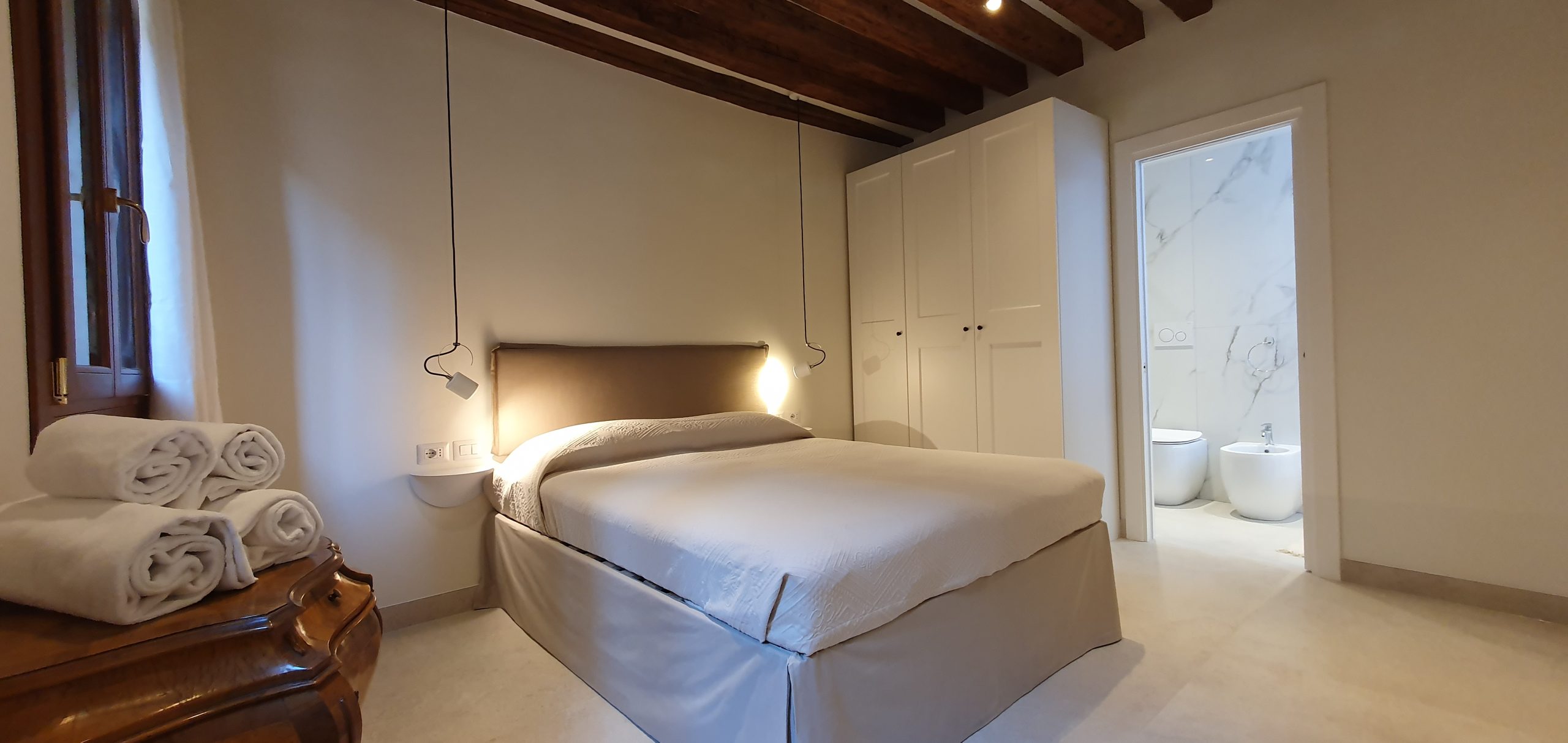 Camera da letto matrimoniale con travi di legno a vista a Venezia