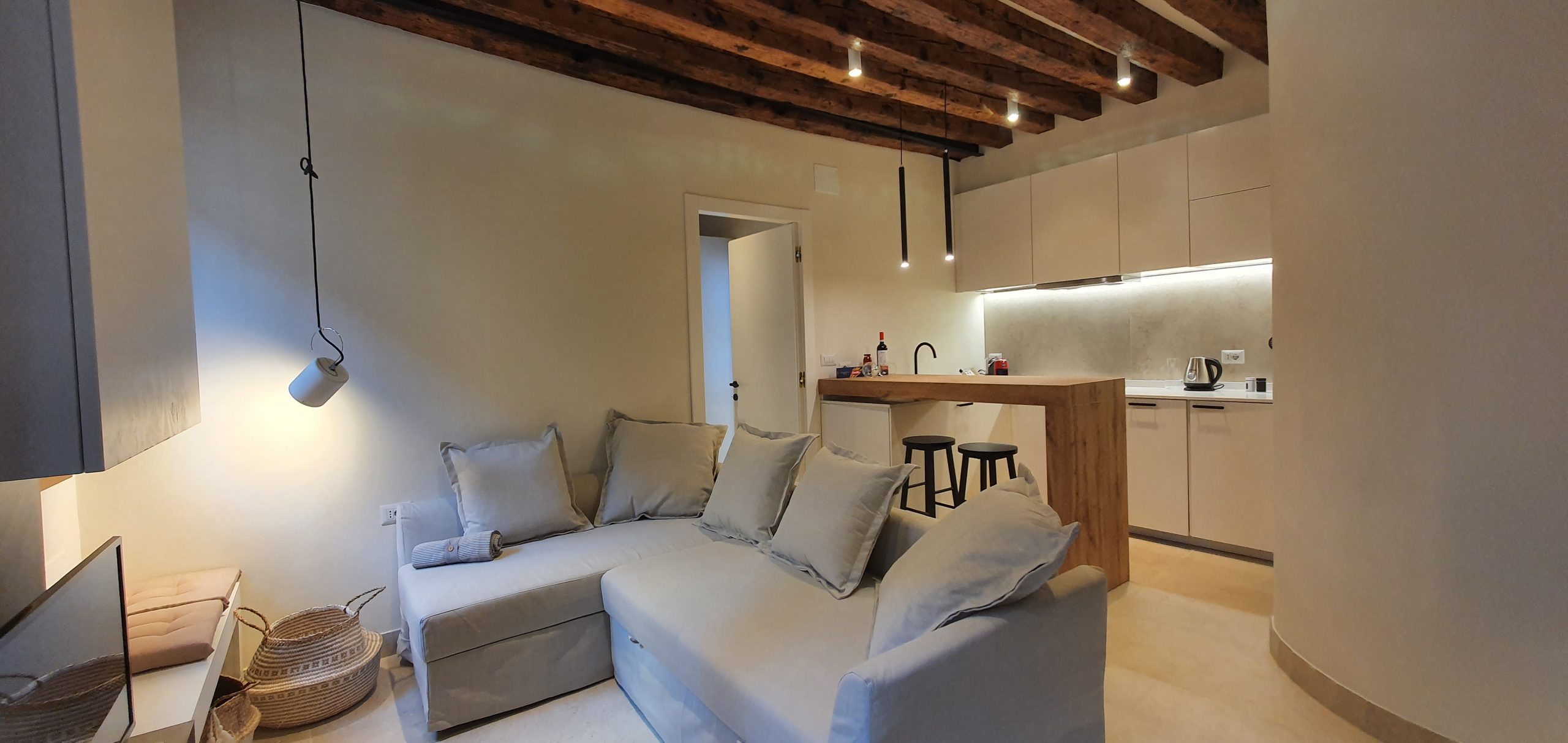 Zona cucina e soggiorno con travi di legno a vista a Venezia