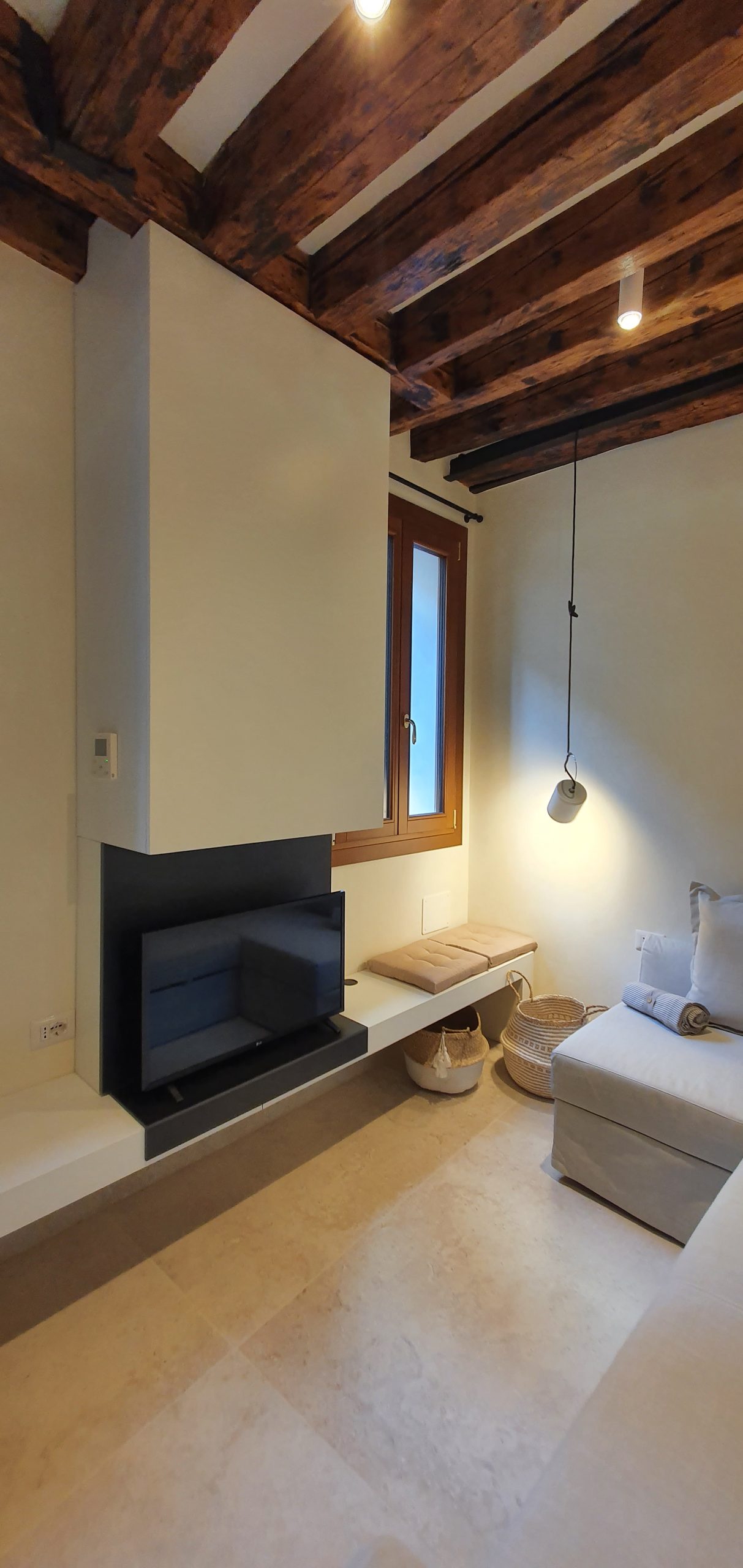 Zona cucina e soggiorno con travi di legno a vista a Venezia