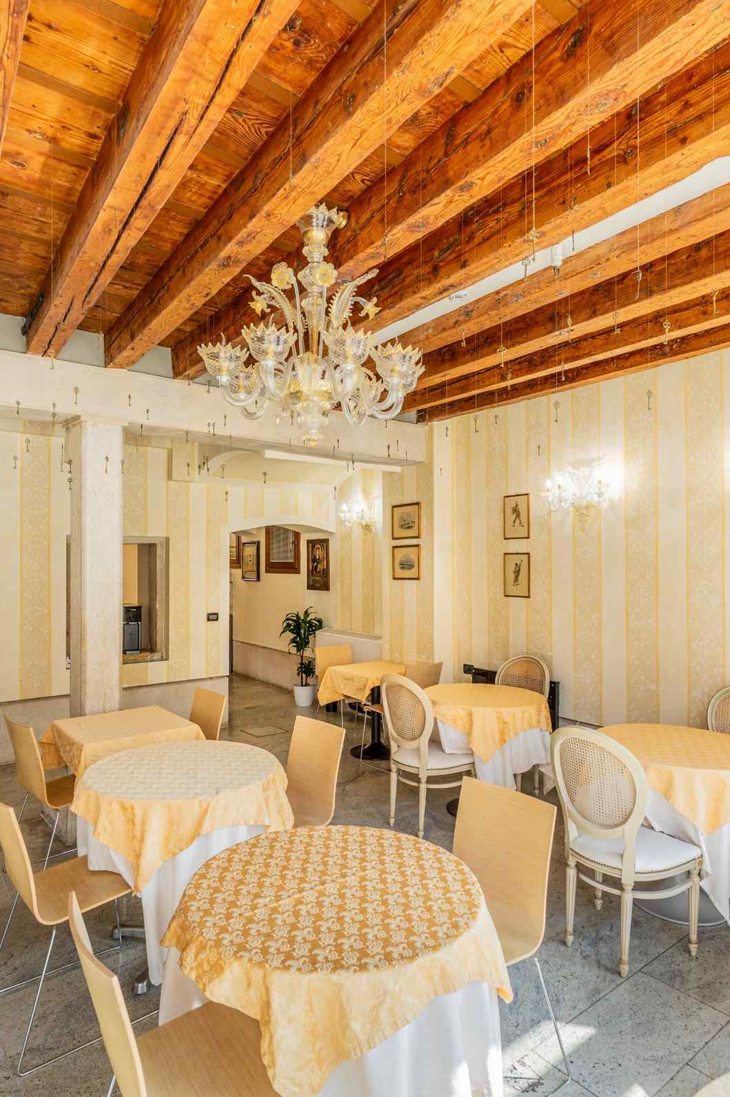 Sala da pranzo con pavimento in pietra e travi solaio in legno a vista a Venezia