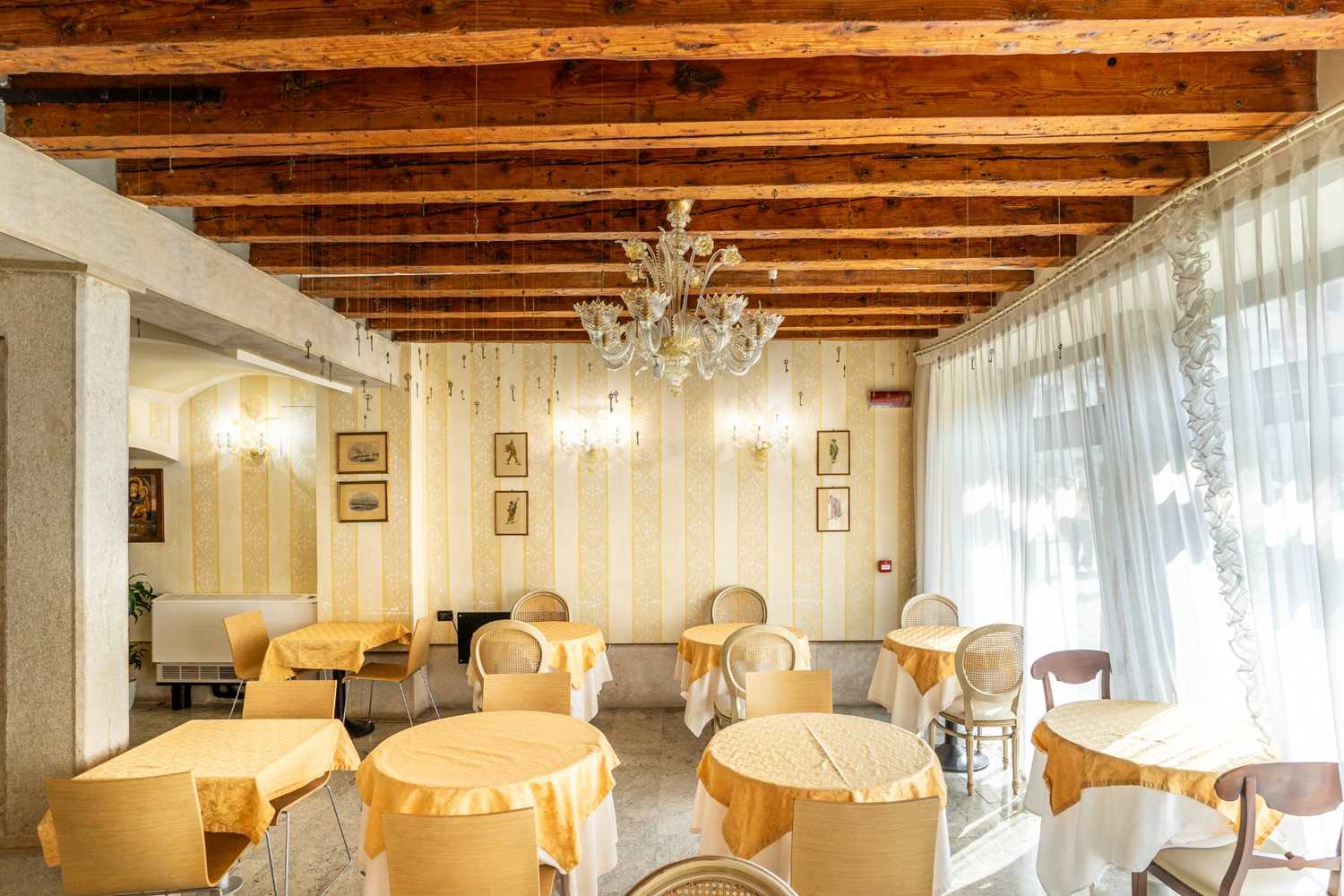 Sala da pranzo con pavimento in pietra e travi solaio in legno a vista a Venezia