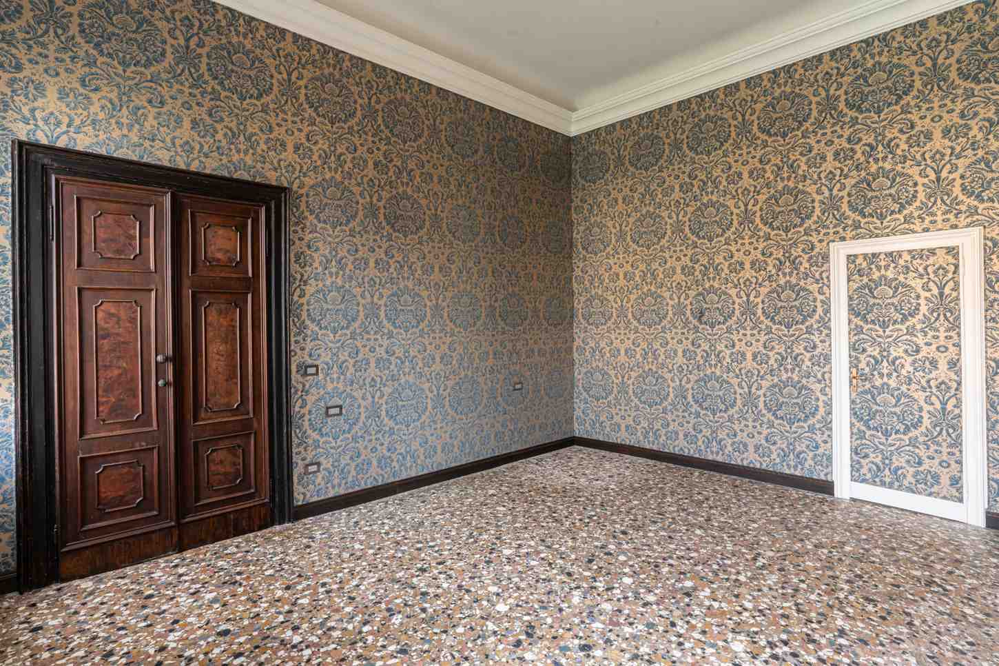 Stanza con porta mimetizzata dalla carta da parati a Venezia
