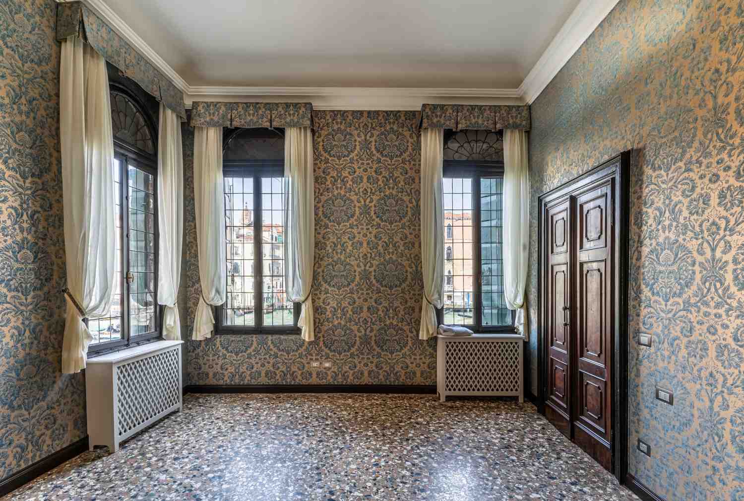 Stanza con carta da parati e pavimento alla veneziana con affaccio su Canal Grande a Venezia