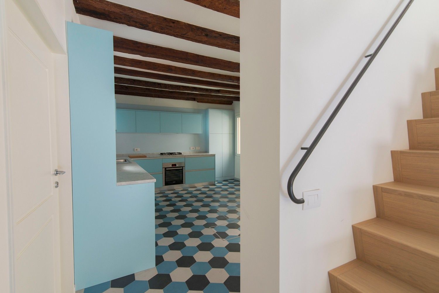 Cucina con travi a vista e pavimentazione policroma a Venezia 