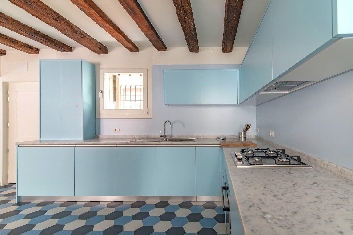 Cucina con travi a vista e pavimentazione policroma a Venezia 